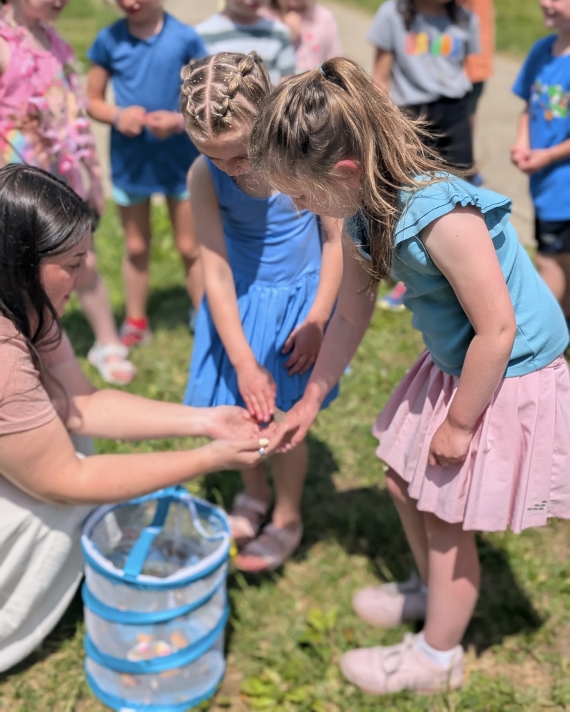 Student holding a butterfly with teacher