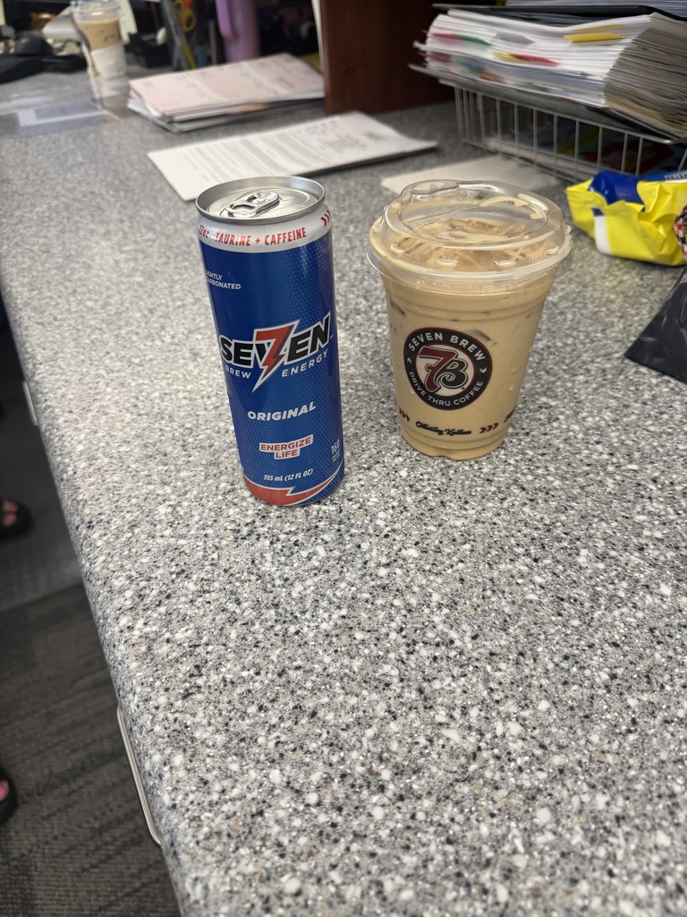 An energy drink can saying seven brew energy original and a coffee cup with an ice coffee in it from seven brew sitting on a counter