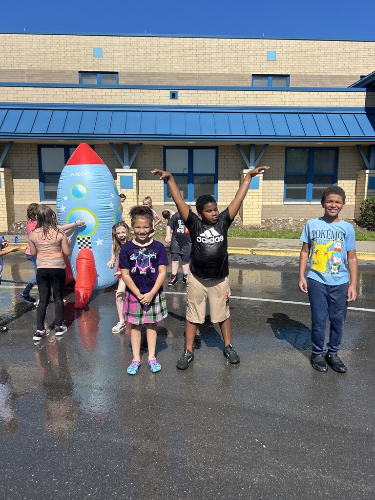 Third grade group of students posing in front of the Rocket water sprinkler