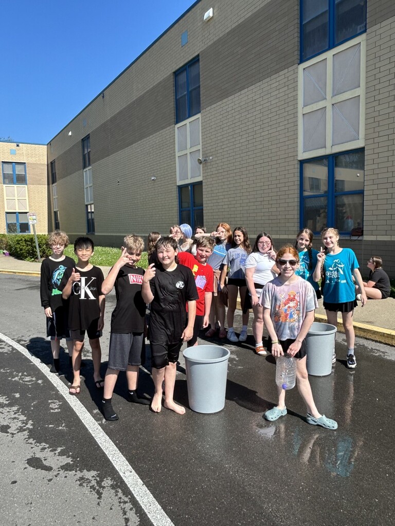 Fifth grade boys and girls posing at a water relay station on skyview Gives Back Day