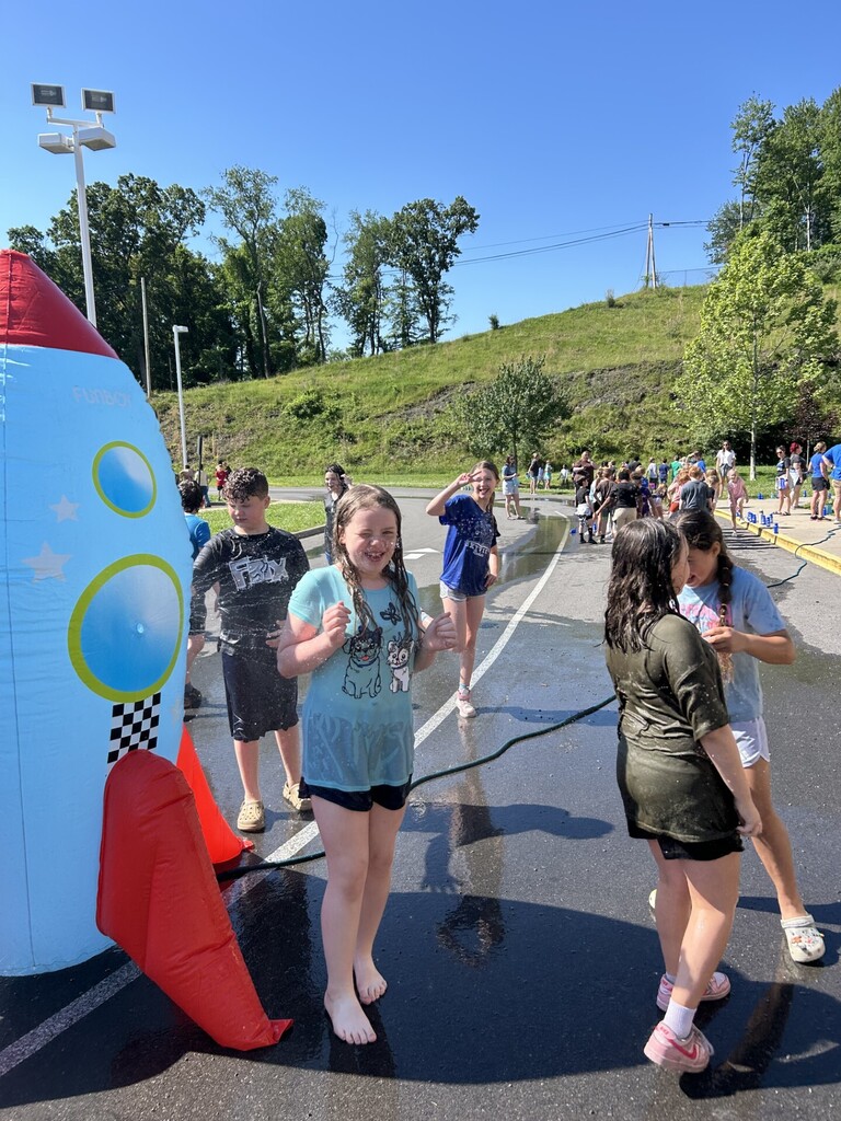 Group of 4th graders playing in a rocket water sprinkler