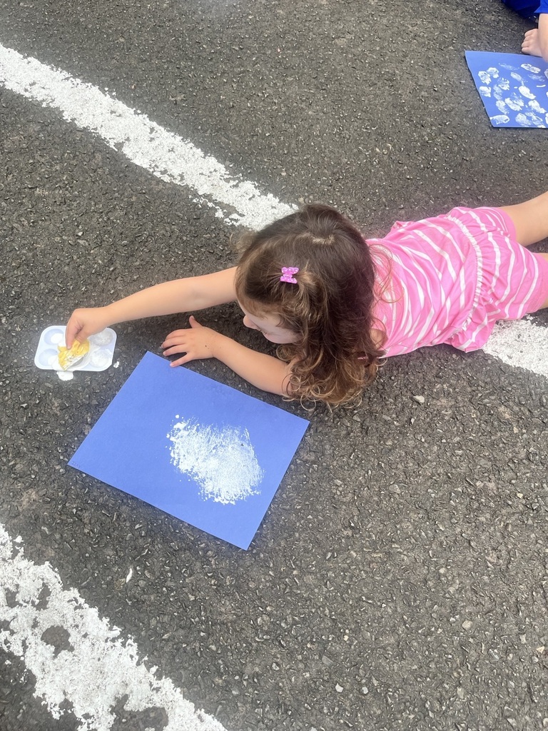 Pre K student painting with a sponge
