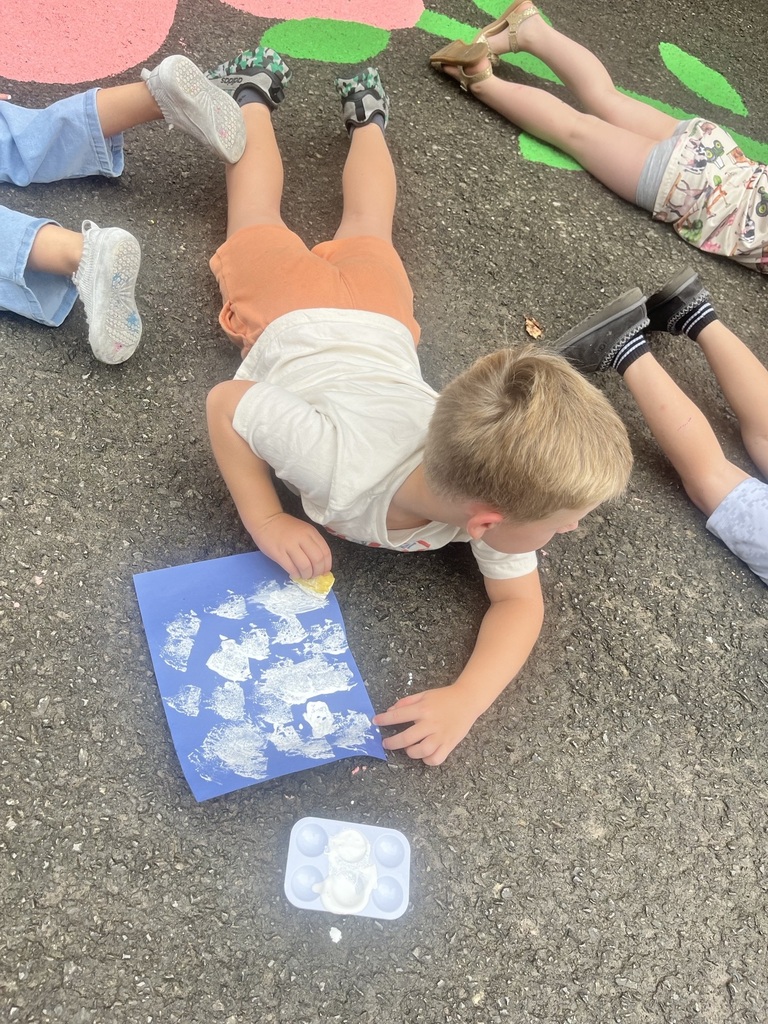 Prek student painting with a sponge