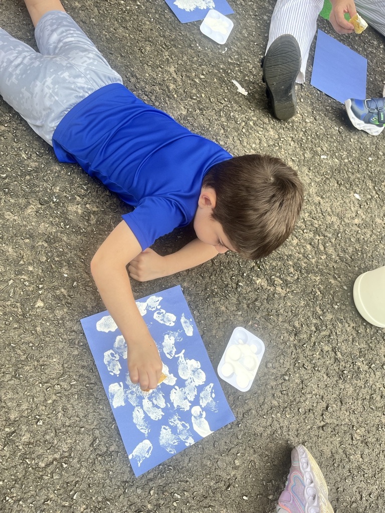 Pre K student painting with a sponge