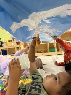 Pre K students painting clouds