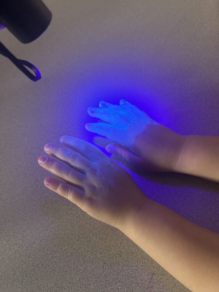 Hands under a black light