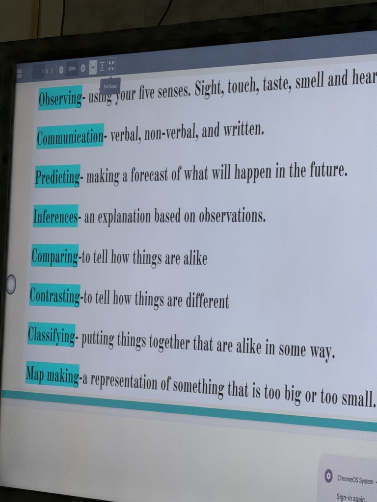 A white board in a classroom with science vocabulary words and definitions on it. The vocabulary words are highlighted blue.