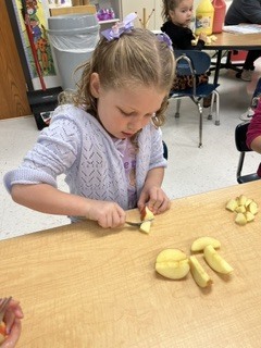 Prek students cutting apples