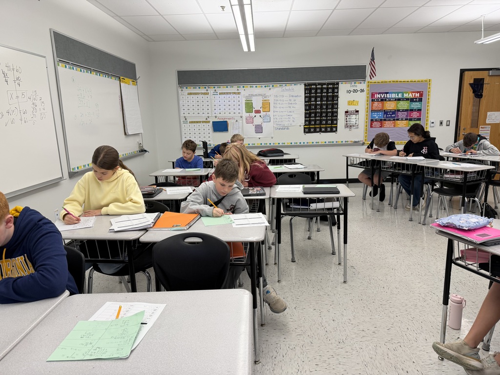 A photo of a math class with students sitting at desks working independently.