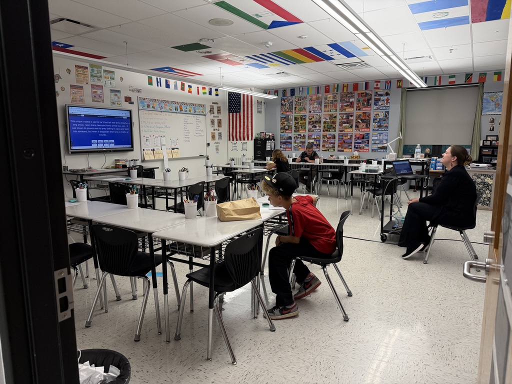 A photo of a classroom where 4 people are sitting.