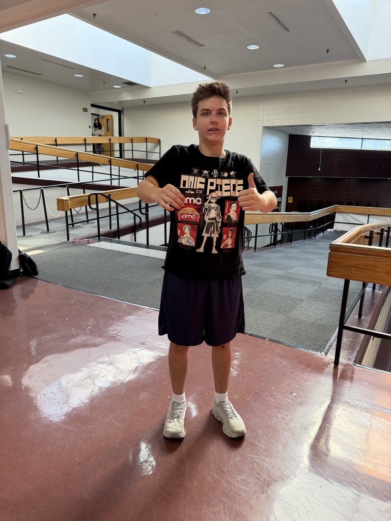 A boy giving a thumbs up and holding an AMC gift card.