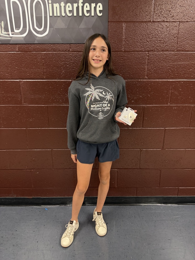 A girl holding a box of Beat ear buds.