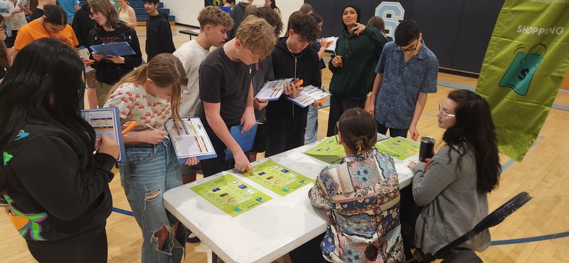 Students shopping for different furniture and amenities during the Get a Life program