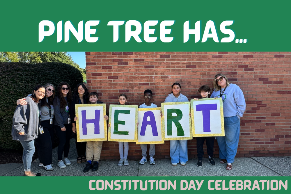 students standing with letters that spell out HEART in front of brick wall with green background