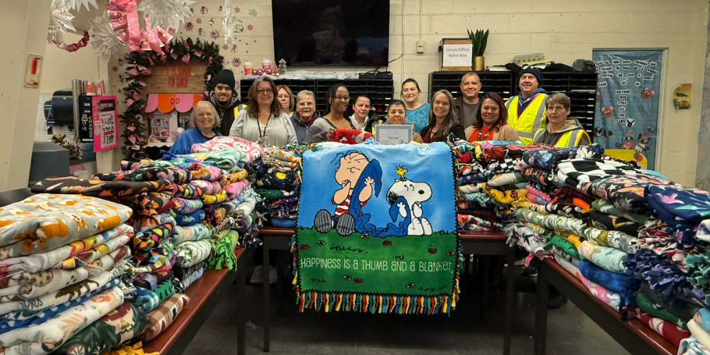 people standing in front of a large amounts of blankets