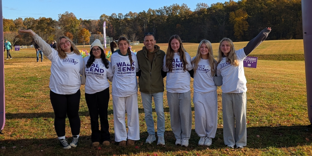 photo of seven people wearing white shirts and jogging pants standing in grass