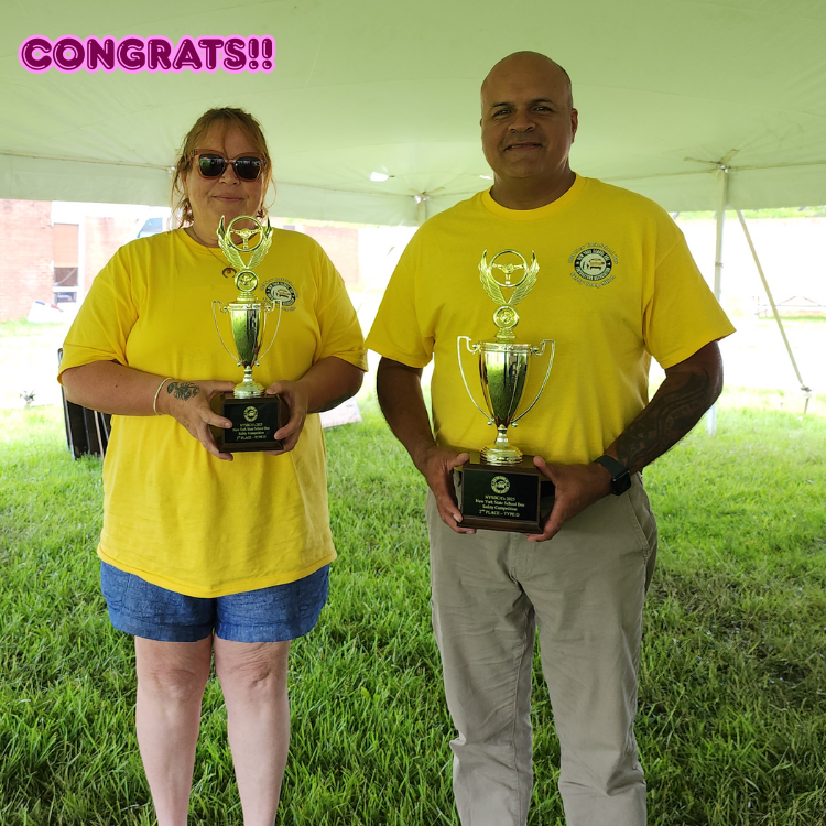 man and woman wearing yellow shirts holding trophies