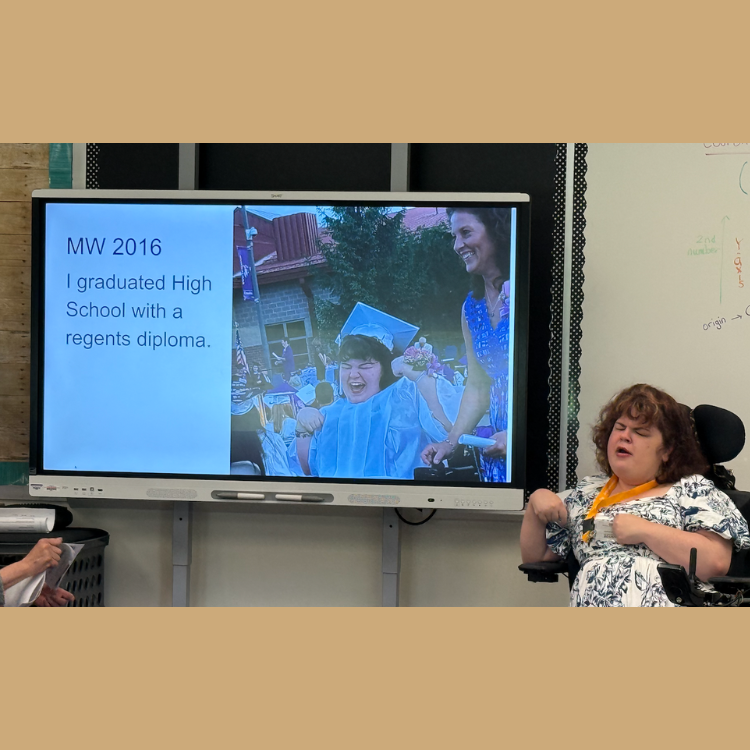 woman in wheelchair sitting next to a smart board