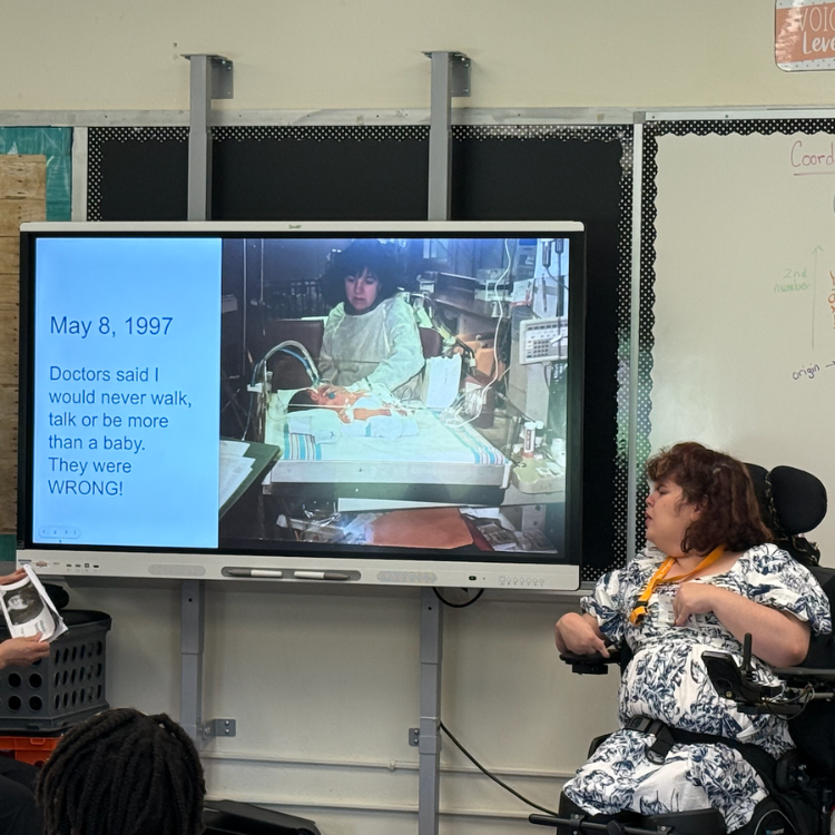woman in wheelchair next to a smartboard