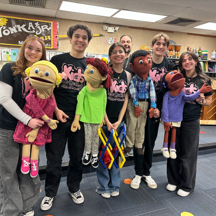 five students holding puppets