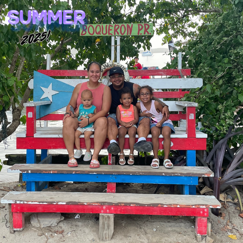 family of 5 sitting on giant chair with red white and blue paint. 