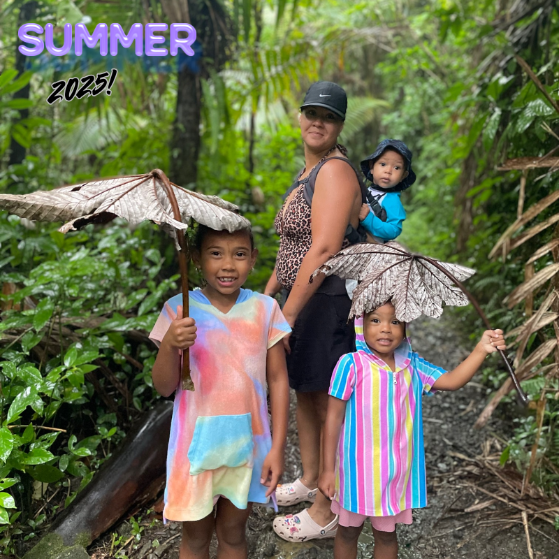 two girls with colorful dresses and woman with a black hat and baby on her back 