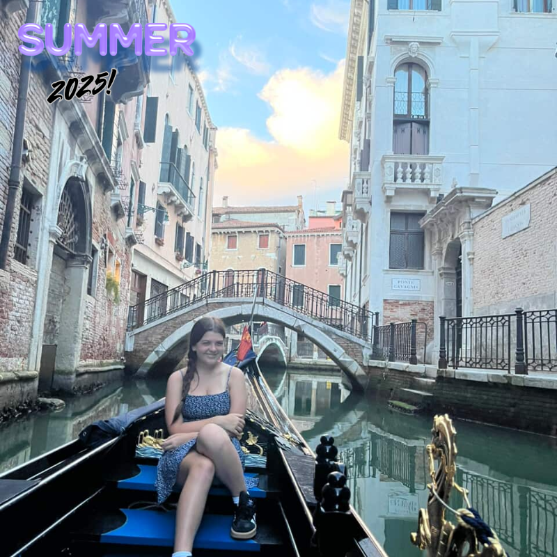 girl wearing a blue dress sitting on a gondola 