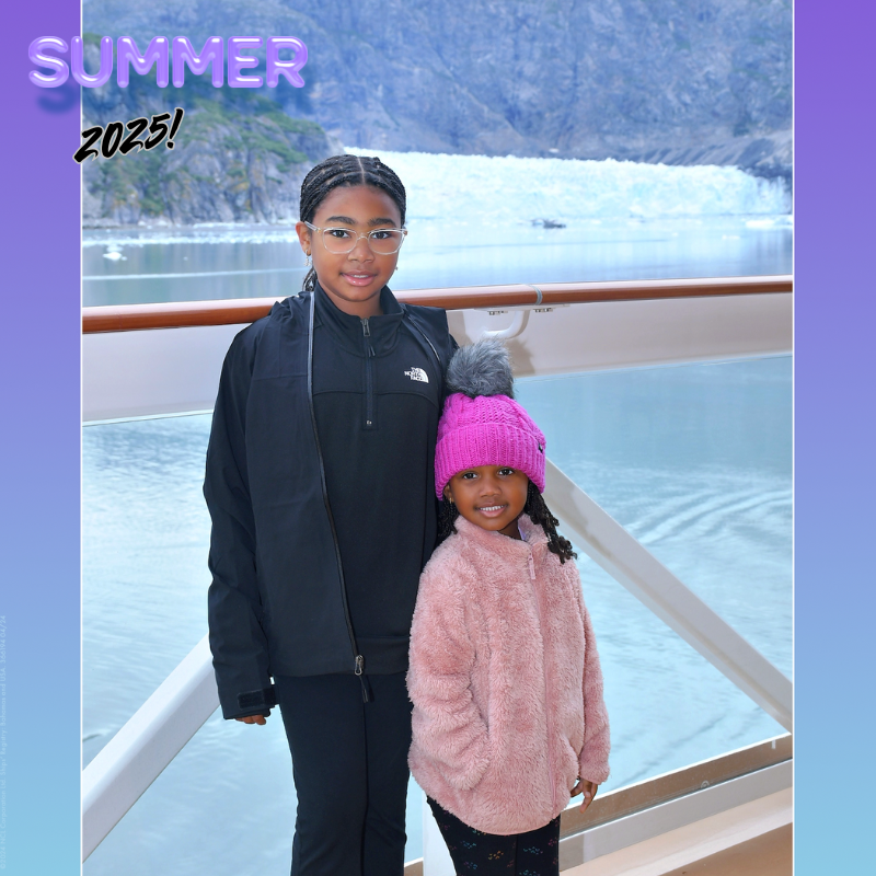 two girls, one wearing all black and one wearing all pink stand on a cruise ship