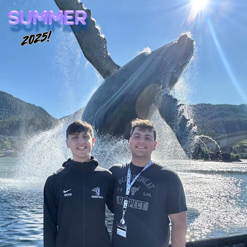 two students standing in front of a whale
