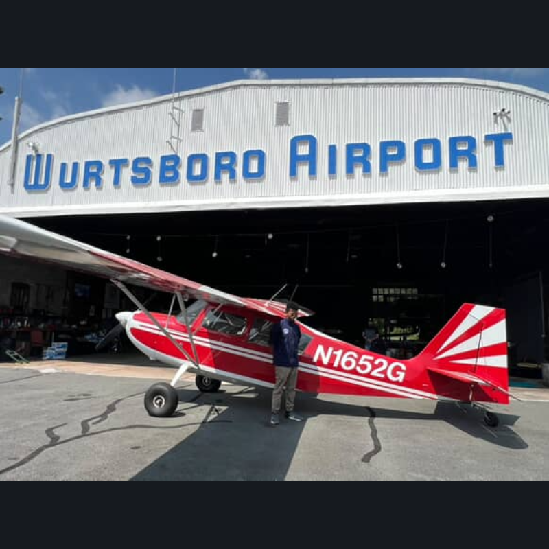 student standing in front of an airplane