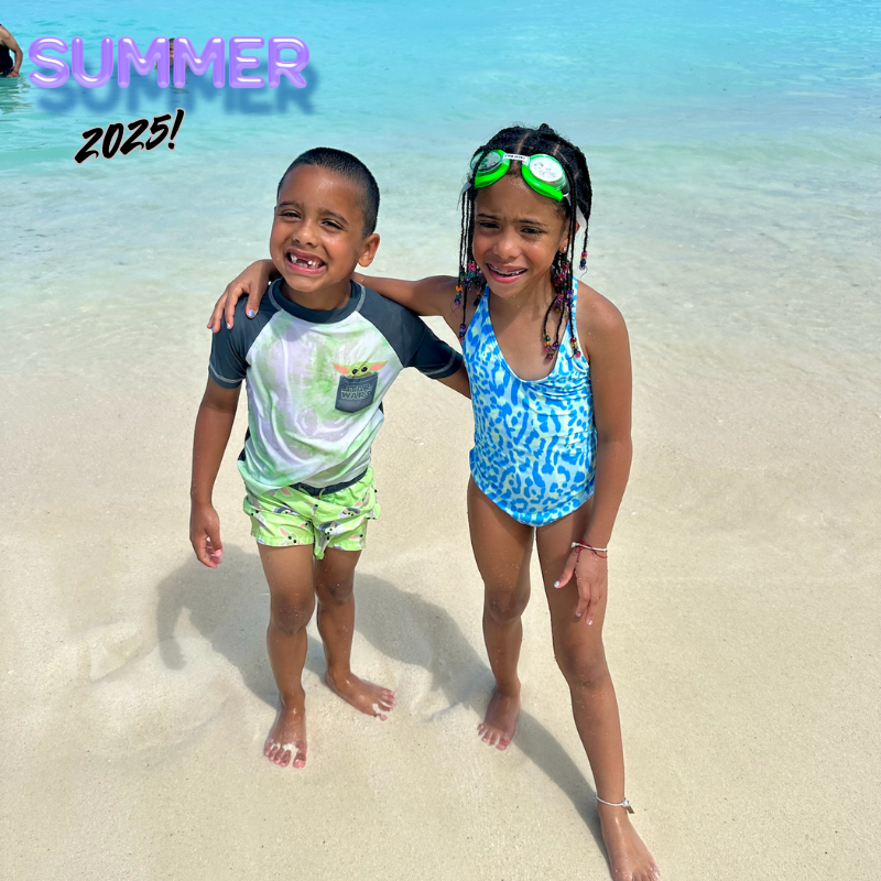 two students on a beach wearing blue and green bathing suits