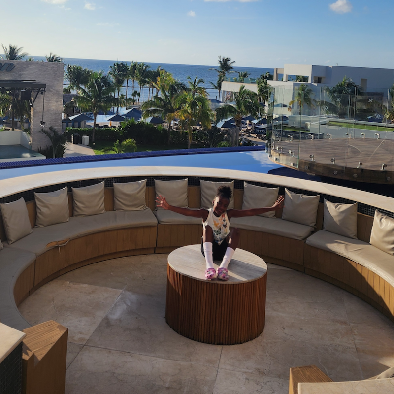 student sitting on a table on the beach