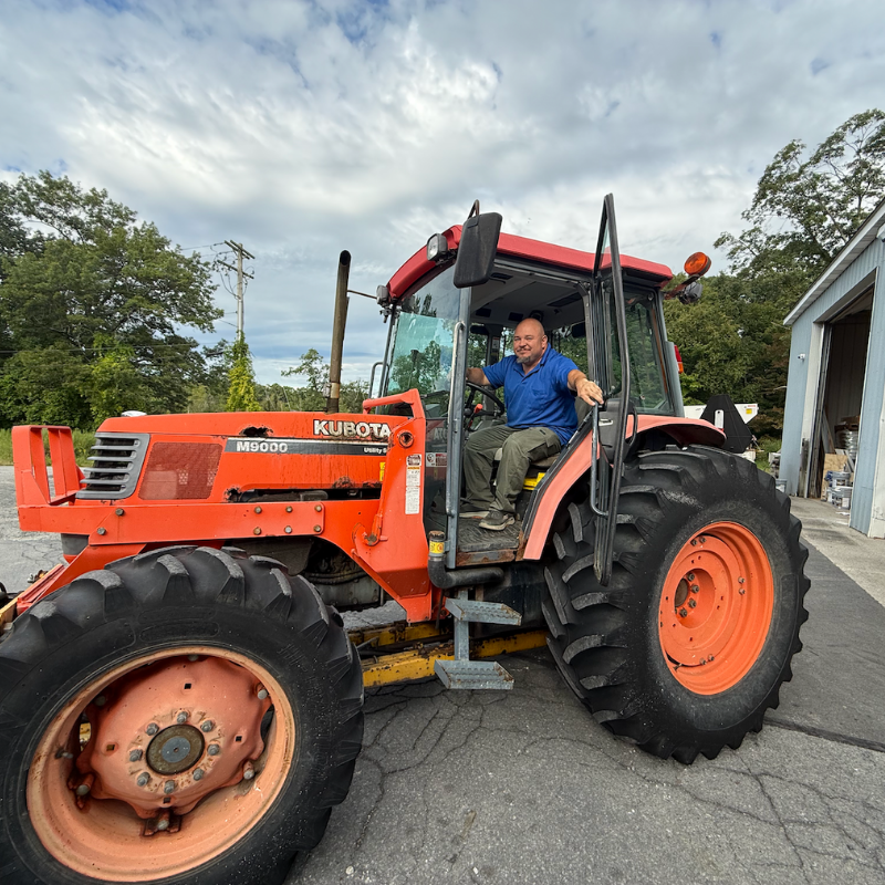 man with a blue shirt sitting in a red truck 