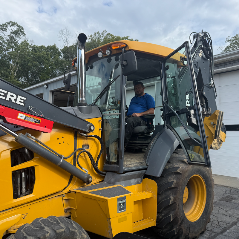 man in a blue shirt on sitting in a yellow truck