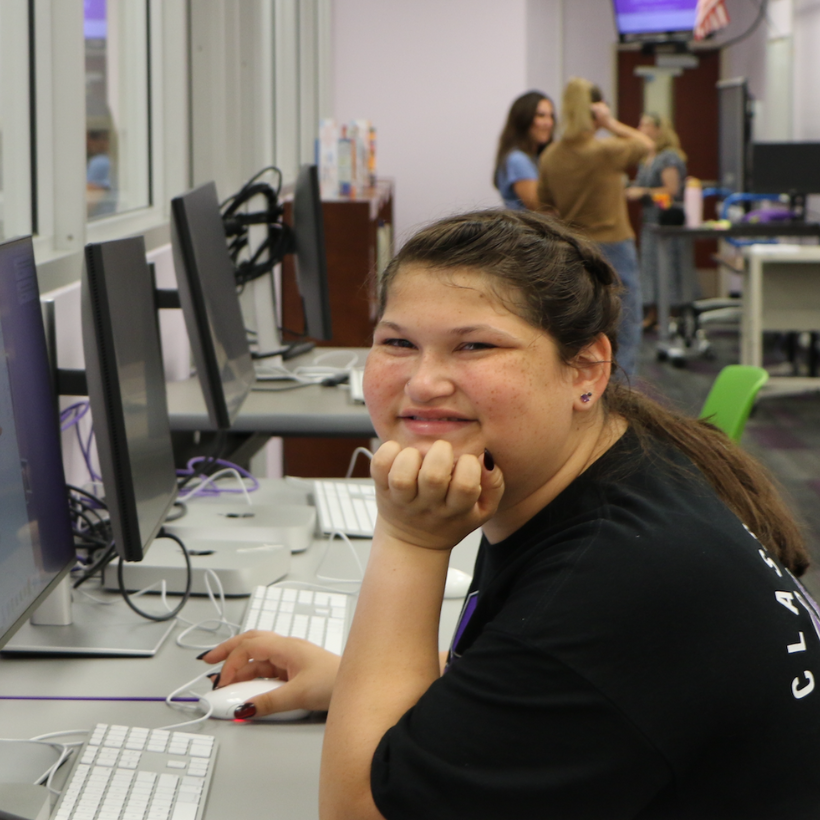 students wearing a black shirt sitting at a computer