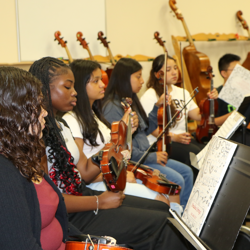 students holding violins in practice