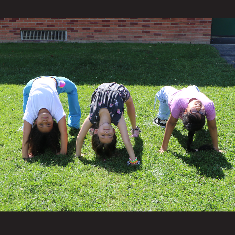 three students posing upside down