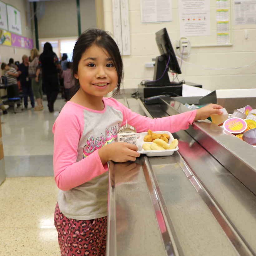 student wearing pink shirt getting lunch