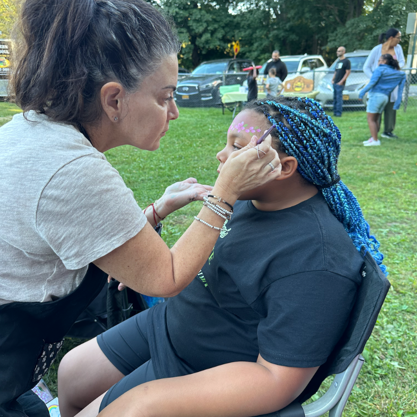 girl with blue braids getting her face painted