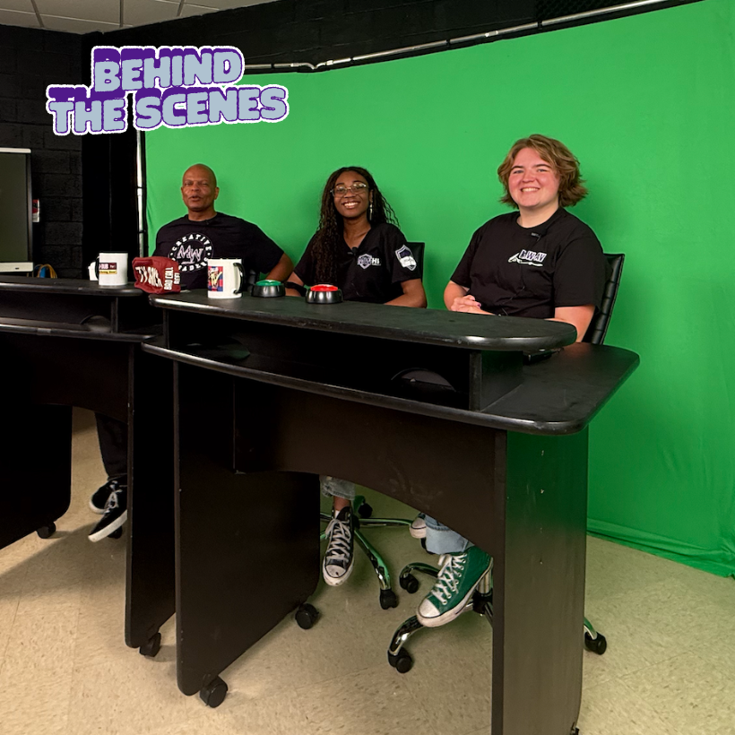 three people wearing black shirts sitting in front of a green screen 