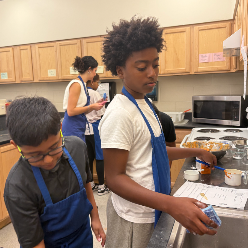 students wearing a blue apron and white and black shirt