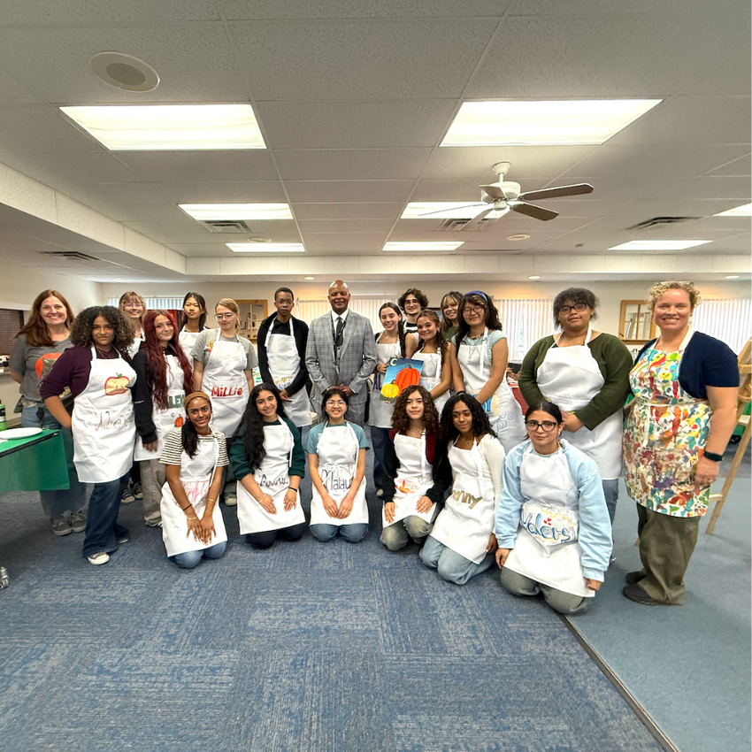 students wearing smocks standing and kneeling