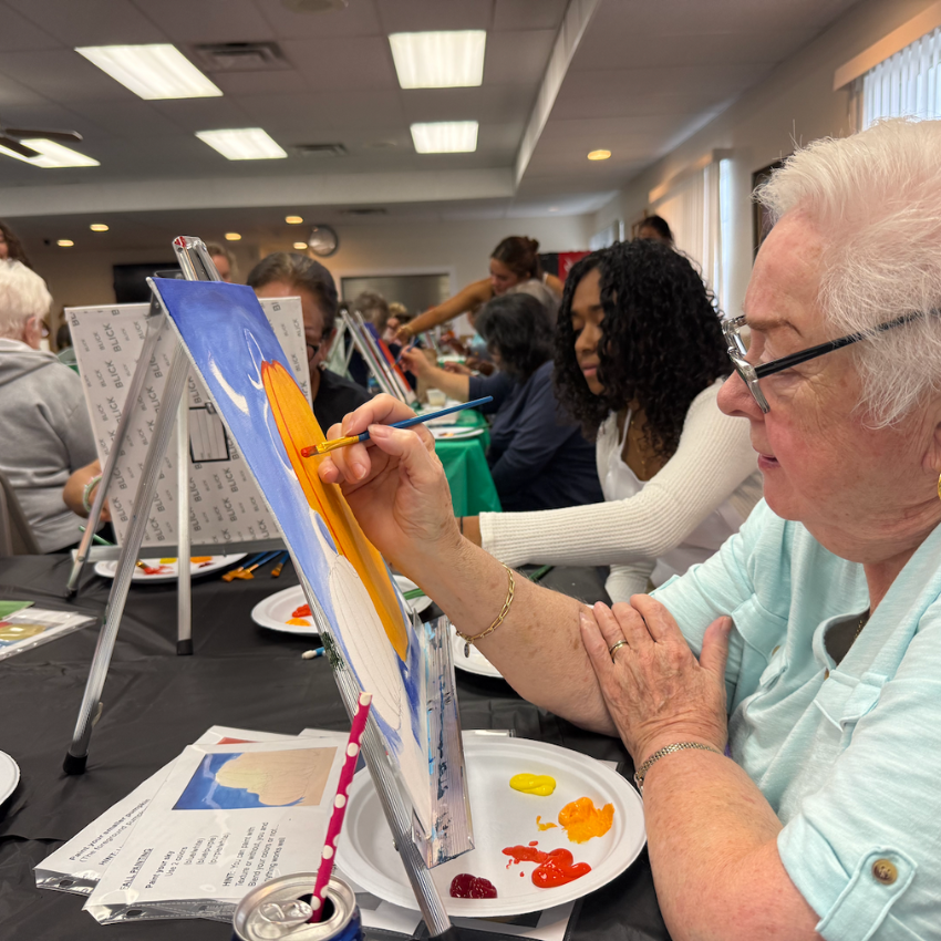 women with blue shirt and student with white shirt painting 