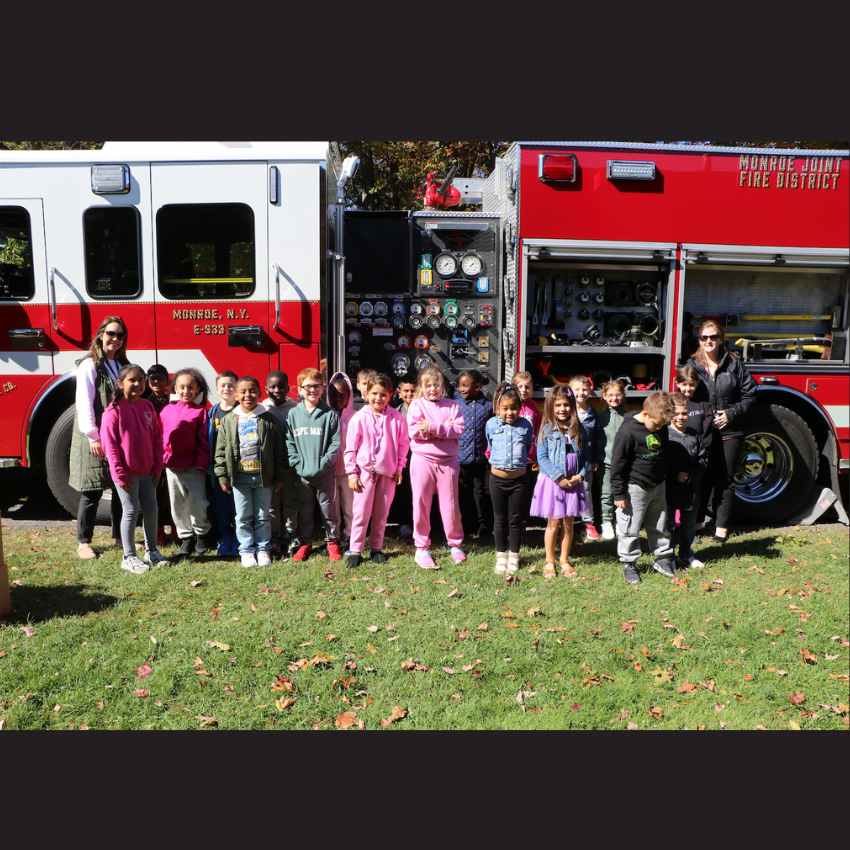 students standing in front of red fire truck 
