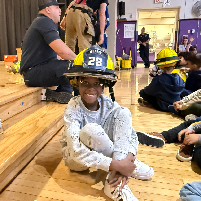 student wearing yellow fire fighter hat