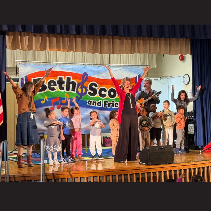 students and teachers standing on a brown stage 