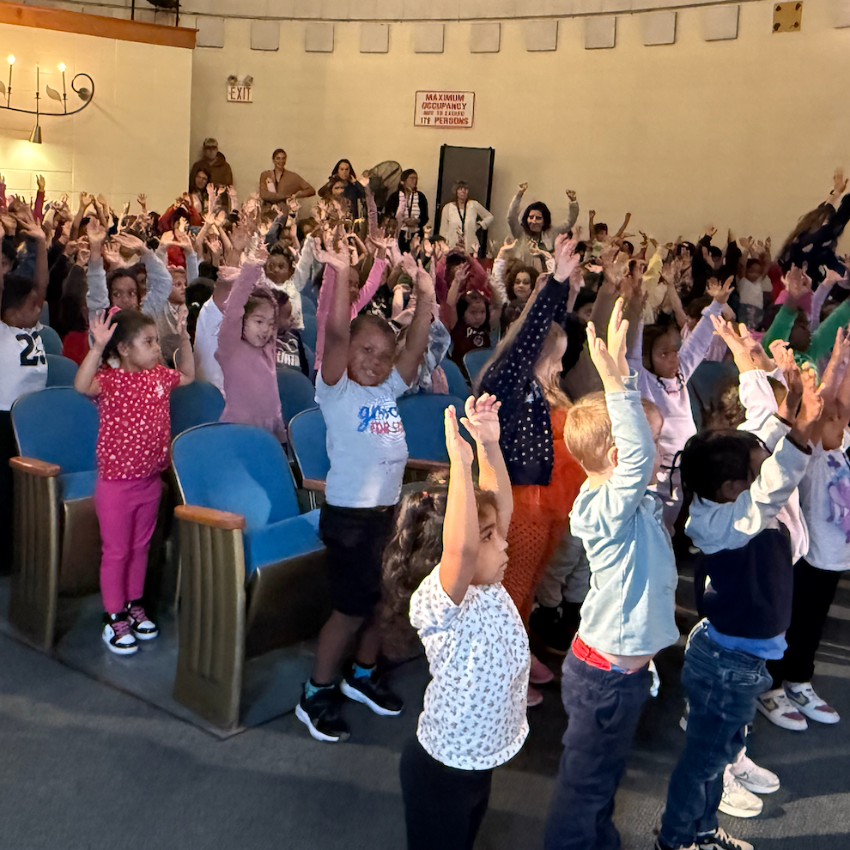 students standing with their hands up