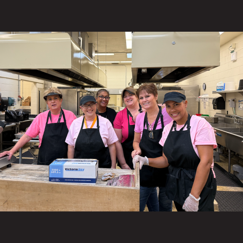 school staff wearing black smocks and pink shirts