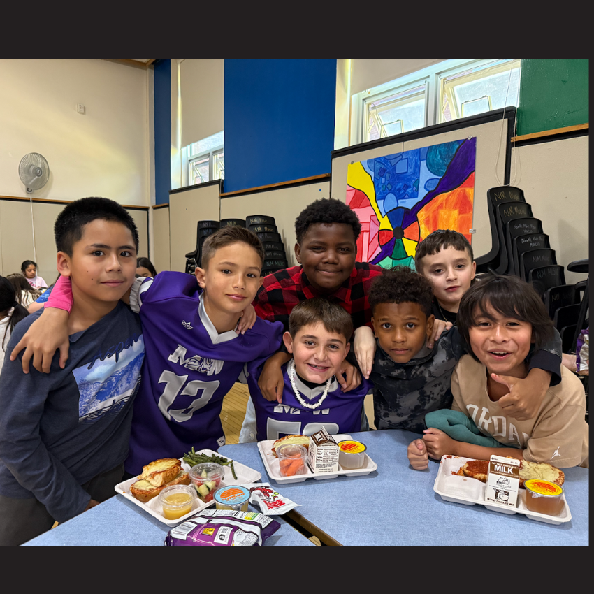 students sitting at a table with lunchtrays