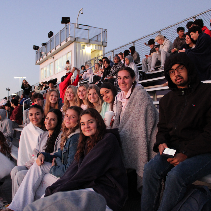 students sitting in the bleachers smiling 